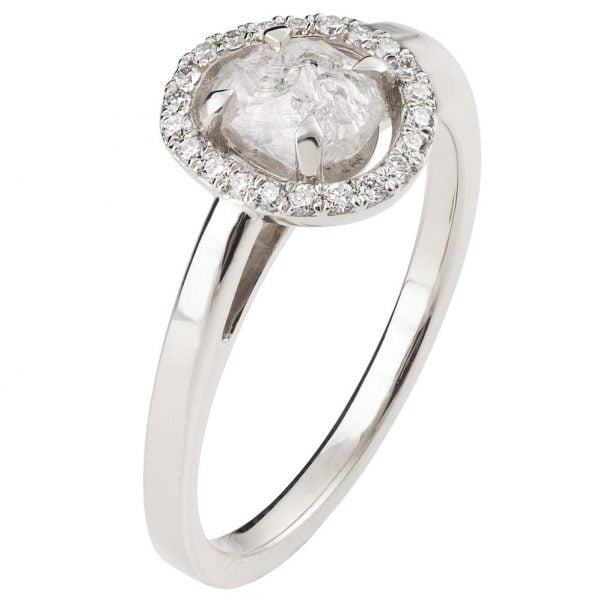 טבעת אירוסין עשויה זהב לבן ומשובצת יהלום גולמי מוקף בהילת יהלומים קטנים טבעות אירוסין